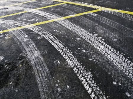 Automotive tire tracks from road salt on asphalt pavement in winter, northern Illinois