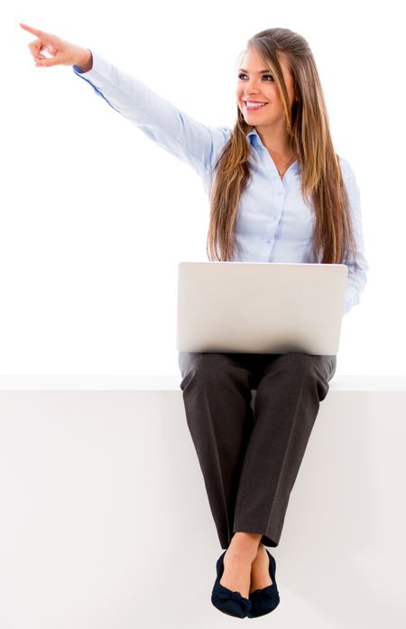 Business woman pointing away with a laptop - isolated over white