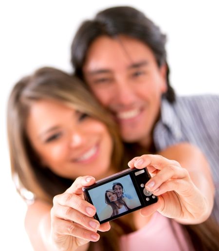 Happy couple taking a picture of themselves with a camera - isolated