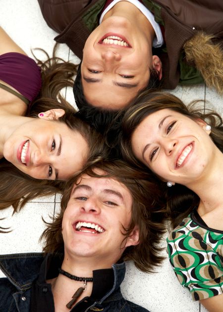 happy group of friends smiling with their heads together on the floor