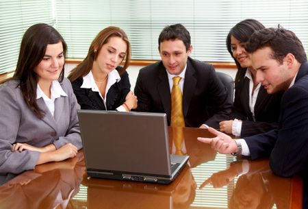 businessmen and businesswomen in a business meeting in an office smiling
