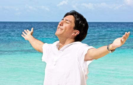man at the beach with his arms open enjoying his freedom while on vacation