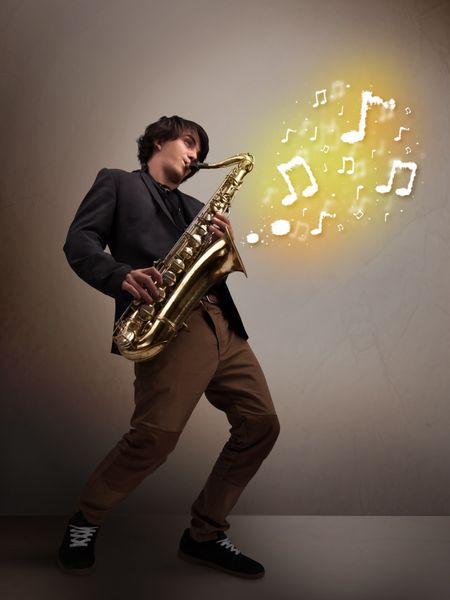 Handsome young musician playing on saxophone with musical notes