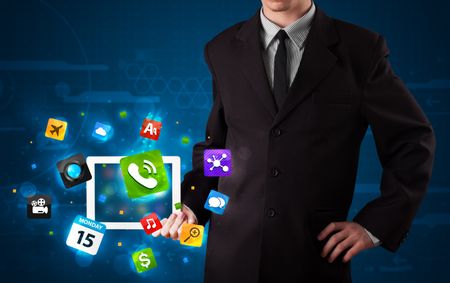 Young businessman holding a tablet with modern colorful apps and icons
