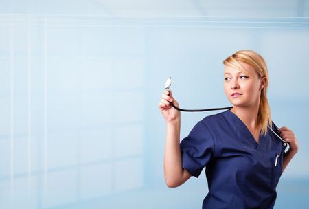 Pretty young nurse in hospital listening to empty copy space with sthetoscope