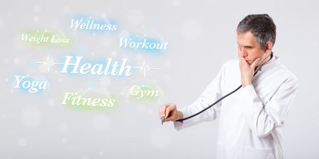 Elderly clinical doctor pointing to health and fitness collection of words