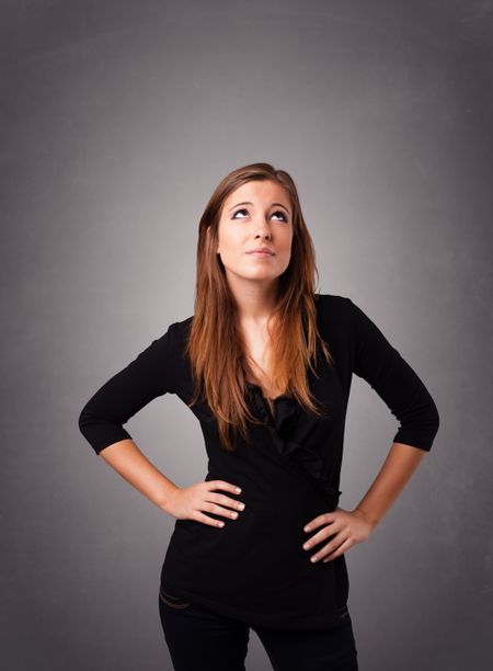 Beautiful young woman standing and thinking with copy space