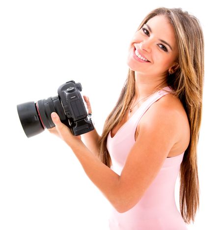 Beautiful photographer holding a camera and smiling