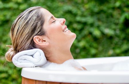 Beautiful relaxed woman in a bathtub with her eyes closed