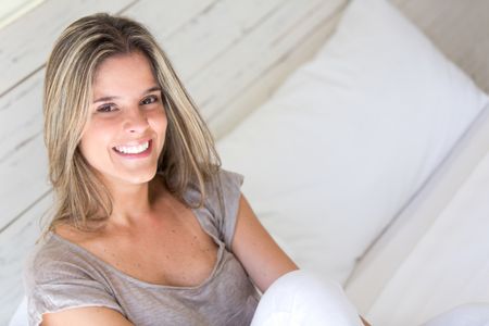 Woman portrait in bed looking very happy and smiling
