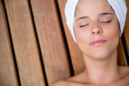 Relaxed woman at the spa enjoying a facial