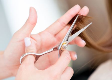 Close up of scissors cutting hair at the beauty salon