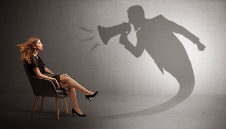Dark shadow yelling with loudspeaker to elegant young lady
