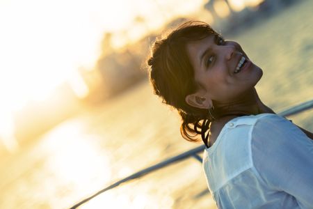 Beautiful woman portrait enjoying the sunset on a boat