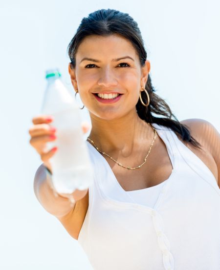 Healthy woman drinking water from a bottle and smiling