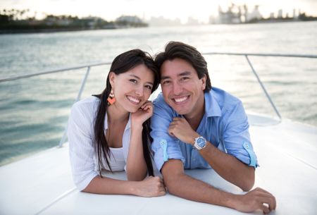 Happy couple in a yacht enjoying sailing and smiling