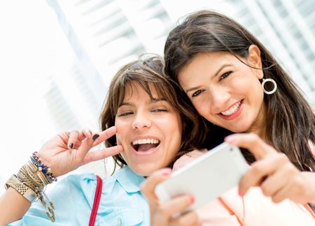 Happy women taking a self portrait with a mobile phone