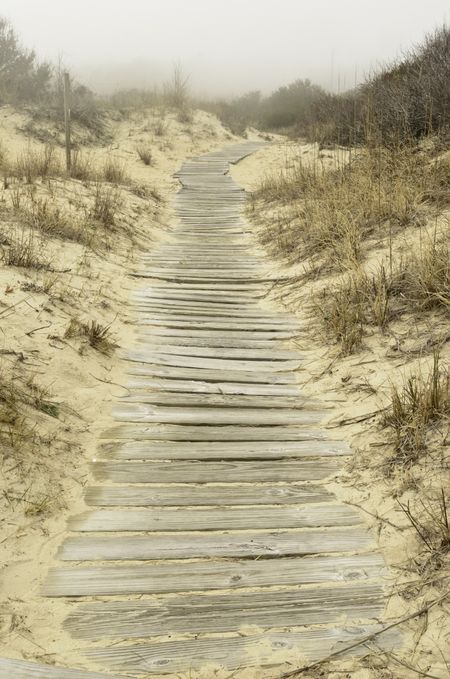 Boardwalk across dunes near foggy beach south of Virginia Beach, Virginia