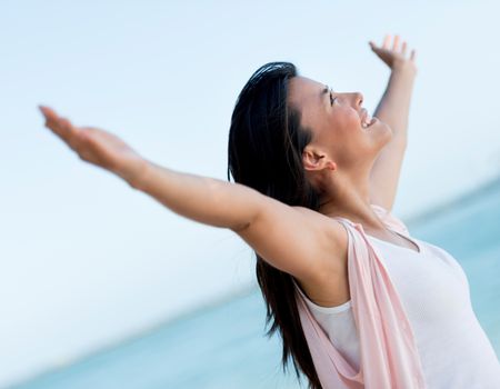 Woman with arms open looking very happy celebrating