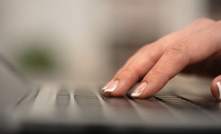 Hand typing on keyboard with office concept