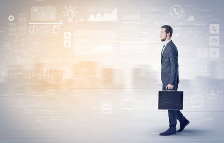 Handsome businessman walking in suit with briefcase on his hand and database concept around