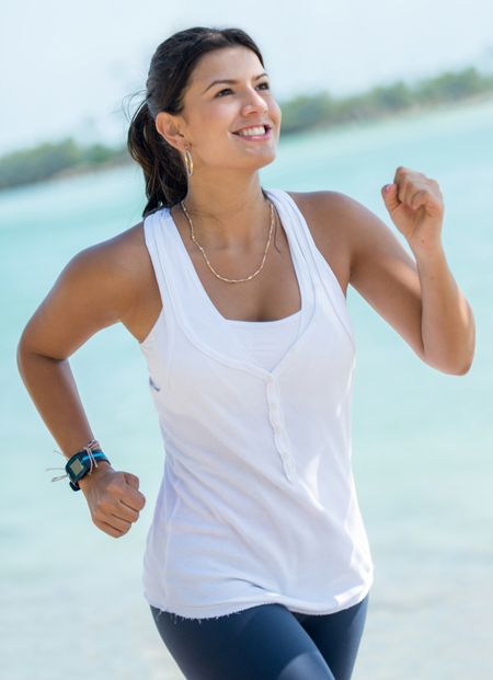 Beautiful fit woman running outdoors by the beach