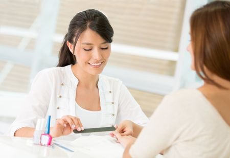 Woman doing a manicure at the nail salon