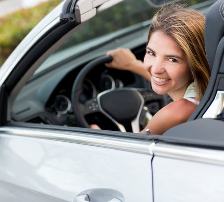 Beautiful woman renting a car and looking very happy