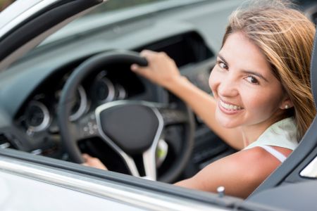 Female driver in a car looking very happy