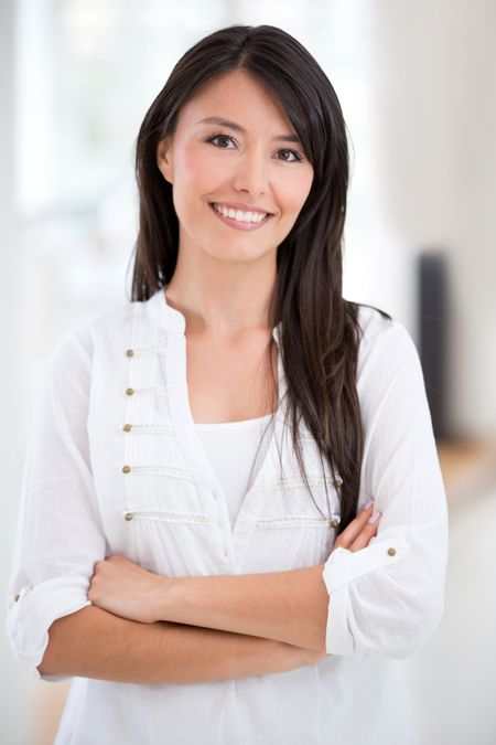 Confident Latin woman with arms crossed smiling