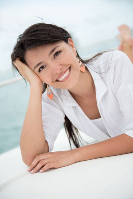 Beautiful summer woman lying on a boat enjoying her holidays