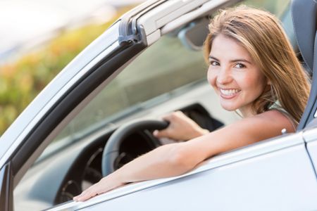 Beautiful woman driving a car and looking very happy