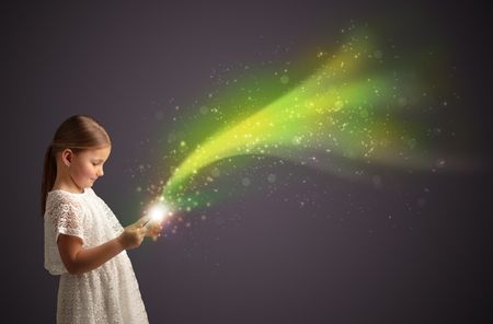 Little cute girl playing on sparkling tablet