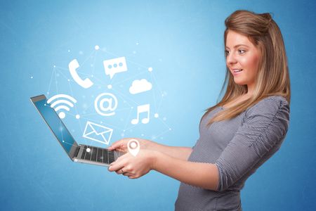 Woman holding laptop with online services symbols