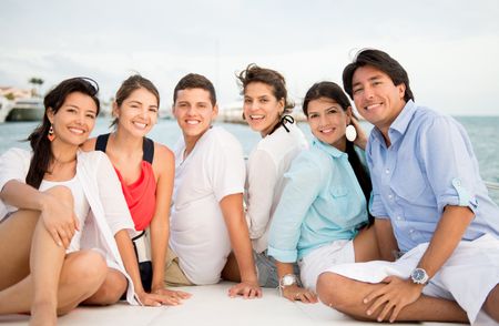 Happy group of friends on a boat enjoying the summer