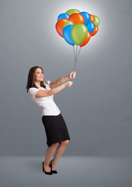 Pretty young woman holding colorful balloons