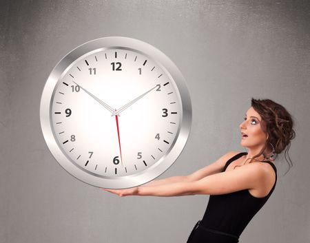 Attractive young lady holding a huge clock