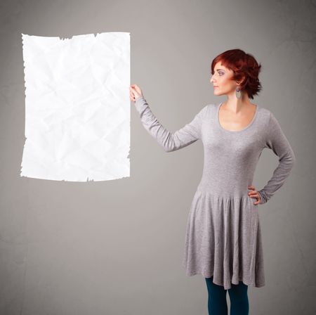 Beautiful young girl holding crumpled white paper copy space