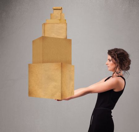 Attractive young lady holding a set of brown cardboard boxes