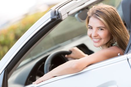 Woman on a road trip driving a convertible car