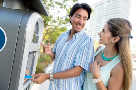 Couple paying for parking with a debit card