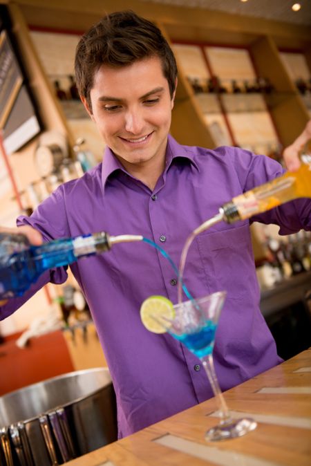 Male barman making a cocktail at the bar