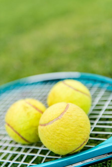 Tennis racket with balls at the court
