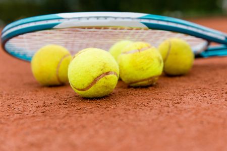 Tennis racket with balls at the court