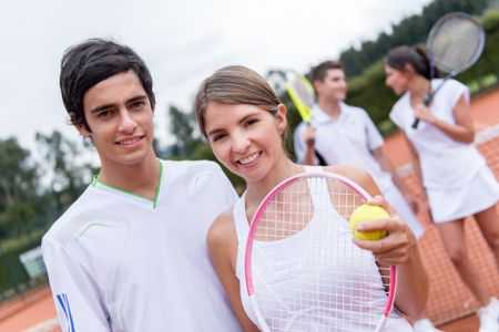 Tennis couple playing doubles at the court looking happy