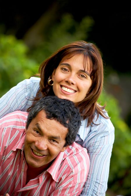 happy couple in their thirties smiling and lying on the grass outdoors