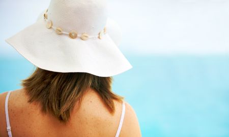 beach woman wearing a hat from behind
