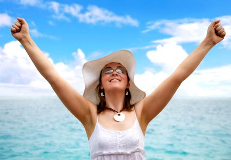 beach woman success with arms open in front of the sea
