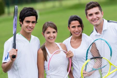 Group of tennis players holding rackets at the court