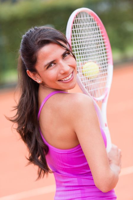 Beautiful woman playing tennis and holding a racket